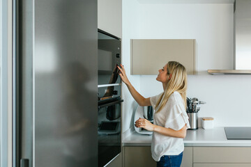 Woman turning on microwave oven