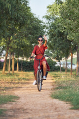Cheerful woman riding bicycle in park