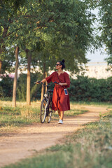 Young Woman walking with bicycle in countryside