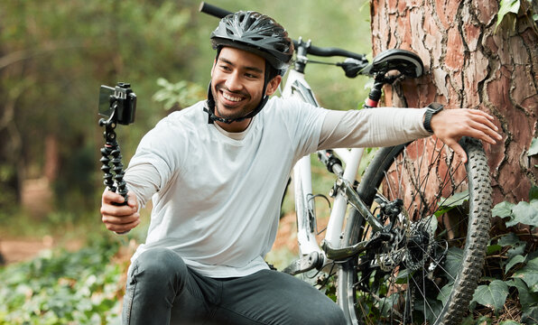 Man, selfie and bike by trees, forest and smile for training, health and outdoor adventure with web blog. Influencer guy, cycling and bicycle with live stream, profile picture and social media post