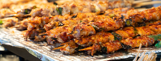 Grilling barbecue meat skewer kebab at traditional night market in South Korea.
