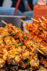 Grilling barbecue meat skewer kebab at traditional night market in South Korea.