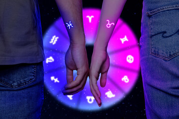 Astrology. Zodiac wheel and couple against black background, closeup