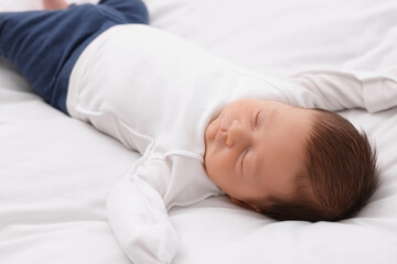 Cute newborn baby sleeping on white blanket, closeup