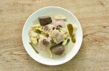 spicy boiled chicken meat and blood with slice cabbage in coconut milk soup or Tom Kha Kai soup Thai food on plate