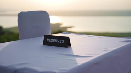 The table is reserved. Cafe or restaurant outside the city. A sign RESERVED on the table of a cafe or restaurant with a lake view