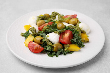 Delicious salad with pesto sauce on light table, closeup