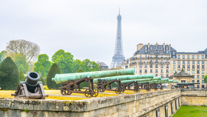 Historical cannons at Les Invalides and parisian cityscape with Eiffel Tower, Paris, France