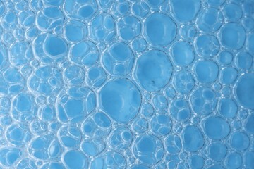 Macro photo of bubbles on light blue background, top view