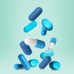 Many different pills falling on light blue background