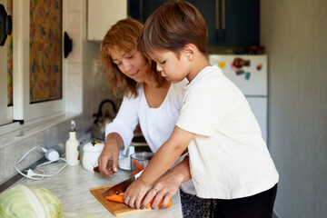 Mother teaches her son how to cook.