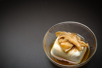 ガラスの器に盛られた豆腐のきのこ餡かけ