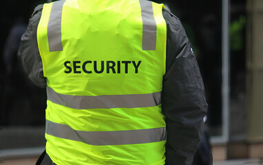 A security guard wearing a high vis vest