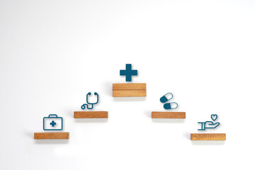 Medical icon symbol on a wooden block cube arranged in steps. Health care, health insurance and treatment  concept.
