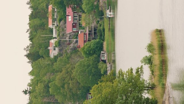 Red Scandic Wooden Houses On Island Coast In Summer Cloudy Day. Nordic Architecture. Travel Concept To Sweden. Scandinavian Culture And Nature. Vertical Footage Video Hyperlapse.