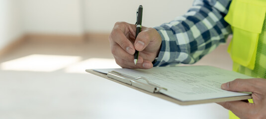 inspector or engineer is inspecting construction and quality assurance new house using a checklist....