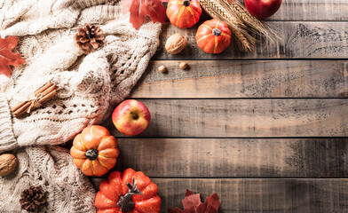 Autumn and thanksgiving decoration concept made from autumn leaves and pumpkin on dark wooden background. Flat lay, top view with copy space.