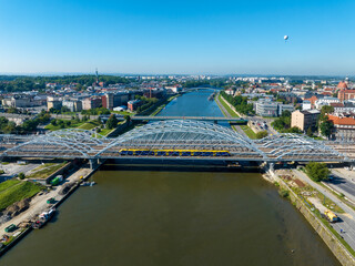 New triple tied-arc railway bridge with running train over Vistula river in Krakow, Poland,  Other...