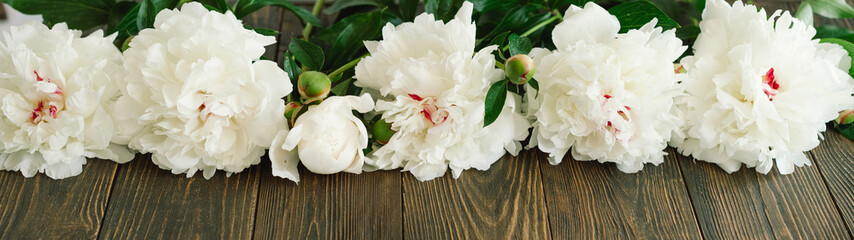 Bouquet of beautiful white peonies on wood background. Stylish floral greetings. Mothers day