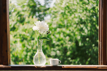 Cup coffee and white peonies on a wooden window. Romantic concept. Vintage style