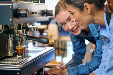 Focusing on pour coffee water into glass shot from coffee machine and emotion face of barista for...