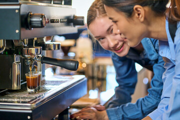 Focusing on pour coffee water into glass shot from coffee machine and emotion face of barista for serve customer.