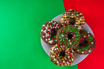 Bright festive decorated Christmas and New Year donuts set, with colorful red, green white snowflake sugar sprinkles. Sweet seasonal Christmas dessert