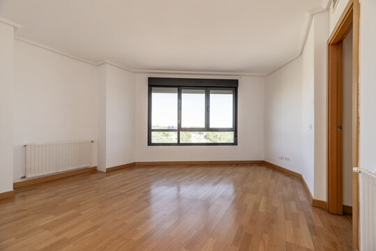 An empty living room with cheap radiators