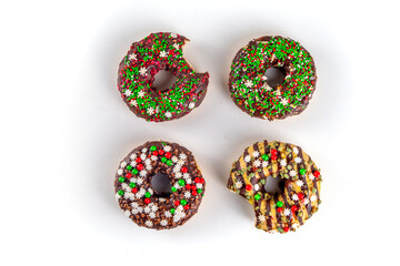 Bright festive decorated Christmas and New Year donuts set, with colorful red, green white snowflake sugar sprinkles. Sweet seasonal Christmas dessert
