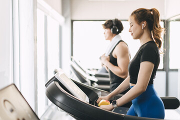 Young people running on a treadmill in health club. Sport fitness healthcare and healthy lifestyle concept.