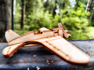 Vintage toy wooden airplane in nature. Private adventure traveling by flight. Aircraft for nature protection, eco friendly, fire extinguishing, rescue of victims. Plane crash, breakdown