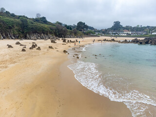 Aerial view on Playa de Toro in Llanes, Green coast of Asturias, North Spain with sandy beaches, cliffs, hidden caves, green fields and mountains.