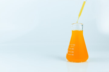 Orange science test tube isolated on white background,Isolated Laboratory Erlenmeyer Flask with liquids of orange color , on white background.