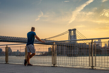 Mann schaut auf die Williams Bridge bei sonnenuntergang