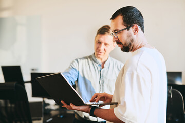 Portrait of two professional male programmers working on computer in diverse offices. Modern IT technologies, development of artificial intelligence, programs, applications and video games concept