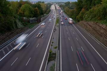 Night lights from car headlights on roundabout in night city. Traces of headlights on the road at night, long exposure. Drone aerial shot. Panoramic aerial view of illuminated road overpass and road