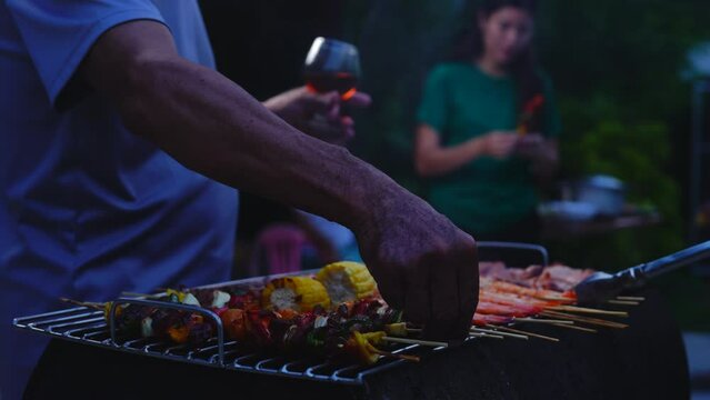 Home Garden BBQ Party, Wine Glasses Clink in Family Toast, enjoying harvest time together outside at front of house, grandfather and grandfather asian people, man and woman