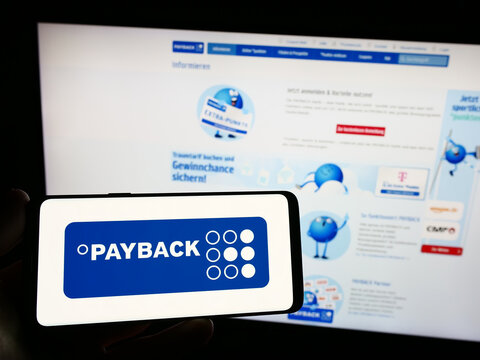 Stuttgart, Germany - 09-01-2023: Person holding smartphone with logo of German loyalty management company Payback GmbH on screen in front of website. Focus on phone display.