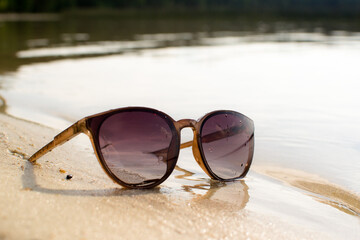 Sunglasses in the sand on the beach, sunny beach, outdoor recreation.