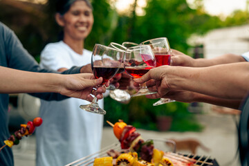 Home Garden BBQ Party, Wine Glasses Clink in Family Toast, enjoying harvest time together outside at front of house, grandfather and grandfather asian people, man and woman