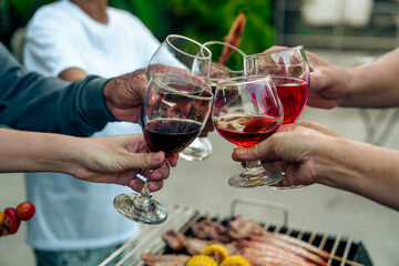 Home Garden BBQ Party, Wine Glasses Clink in Family Toast, enjoying harvest time together outside at front of house, grandfather and grandfather asian people, man and woman