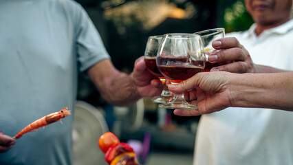 Home Garden BBQ Party, Wine Glasses Clink in Family Toast, enjoying harvest time together outside at front of house, grandfather and grandfather asian people, man and woman