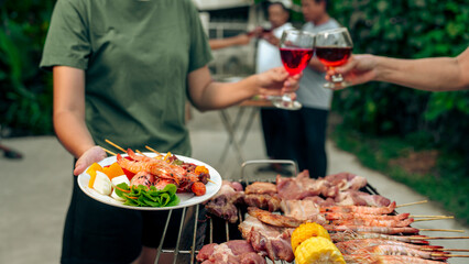 Home Garden BBQ Party, Wine Glasses Clink in Family Toast, enjoying harvest time together outside at front of house, grandfather and grandfather asian people, man and woman