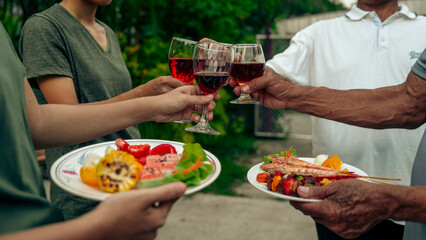 Home Garden BBQ Party, Wine Glasses Clink in Family Toast, enjoying harvest time together outside at front of house, grandfather and grandfather asian people, man and woman