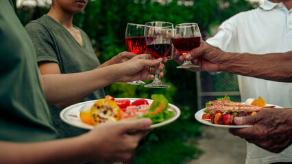 Home Garden BBQ Party, Wine Glasses Clink in Family Toast, enjoying harvest time together outside at front of house, grandfather and grandfather asian people, man and woman