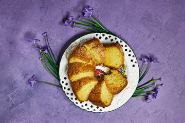 slice of delicious coconut bundt cake in white plates with geranium flowers on purple background