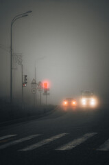 Foggy road with cars and traffic lights on a foggy day
