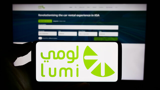 Stuttgart, Germany - 09-02-2023: Person holding cellphone with logo of Saudi Arabian car rental company Lumi on screen in front of business webpage. Focus on phone display.