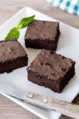 Chocolate brownie portions on wooden background