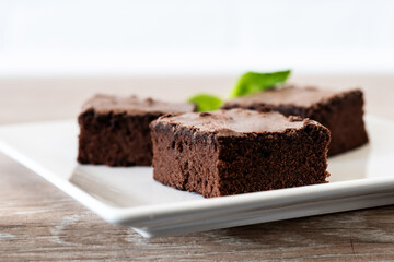 Chocolate brownie portions on wooden background